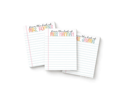 Three small notepads with notebook paper background. There are personalized names at the top of each notepad in bolder pastel rainbow text with "from the desk of" in black cursive above the rainbow pastel text.